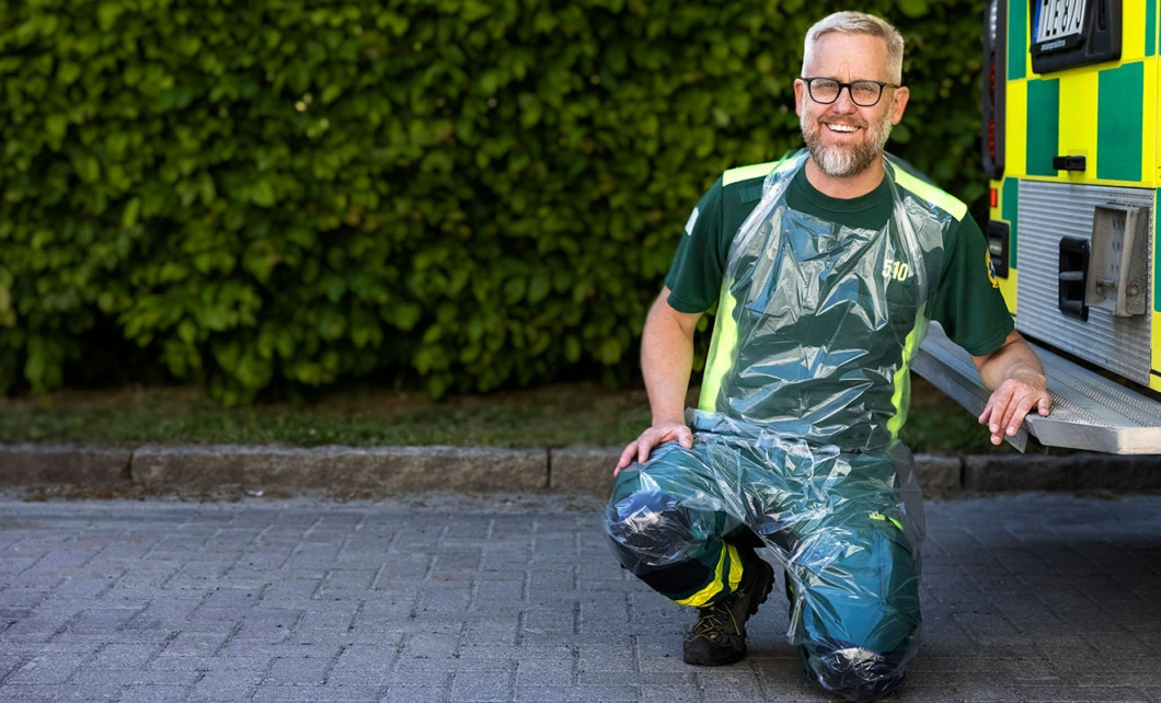 Mattias Lind bär LIMA Byxförkläde framför en ambulans